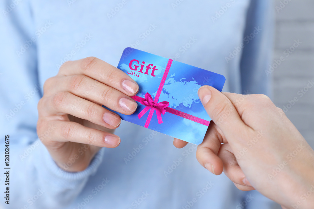 Woman giving gift card to friend, closeup. Holiday celebration concept. Woman giving gift card to friend, closeup. Holiday celebration concept.