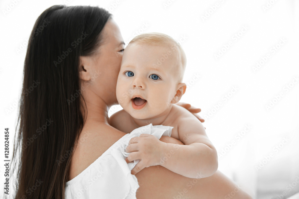Mother holding little baby on light background Mother holding little baby on light background