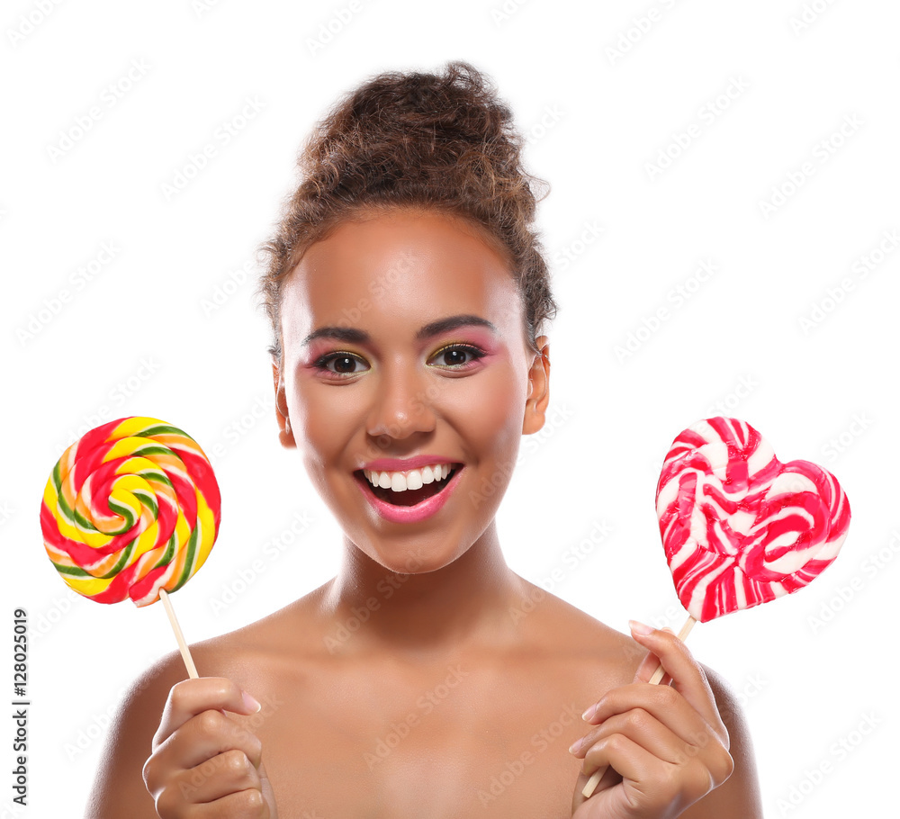 Portrait of smiling young woman with colourful lollipops on white background