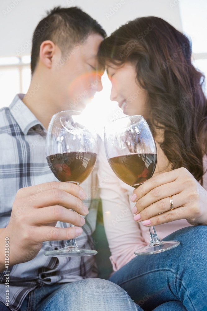 Low angle view of couple holding wineglasses