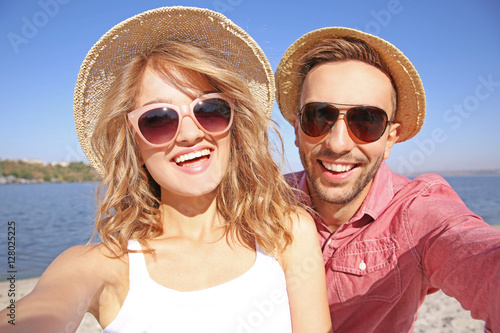 Happy couple taking selfie on beach