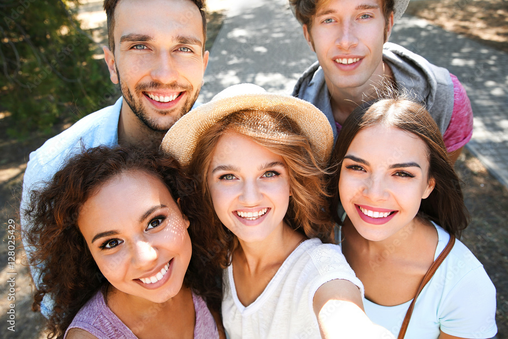 Obraz premium Happy friends taking selfie on street