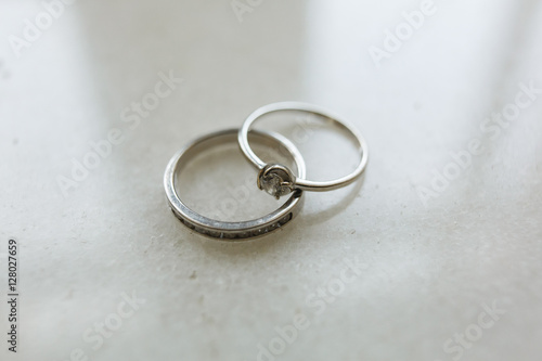 Bride's rings lie on white table