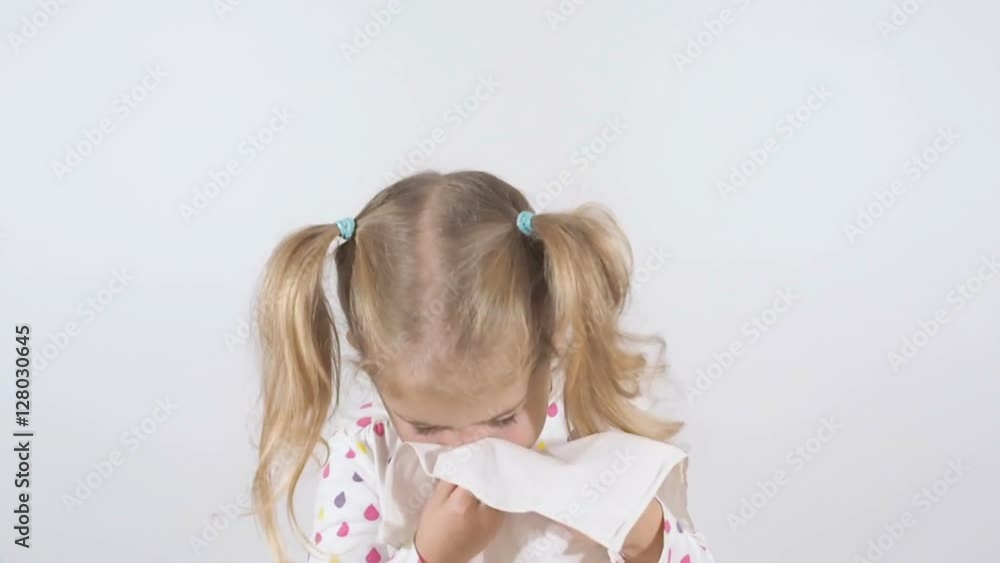 Little Girl with a runny nose. Blowing his nose with disposable tissues isolated on a white background Little Girl with a runny nose. Blowing his nose with disposable tissues isolated on a white background