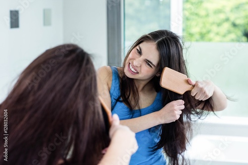 Unsmiling brunette combing