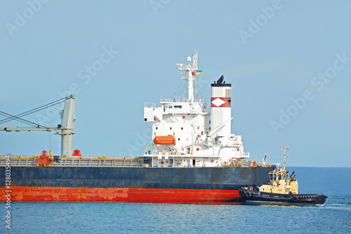 Tugboat assisting bulk cargo ship