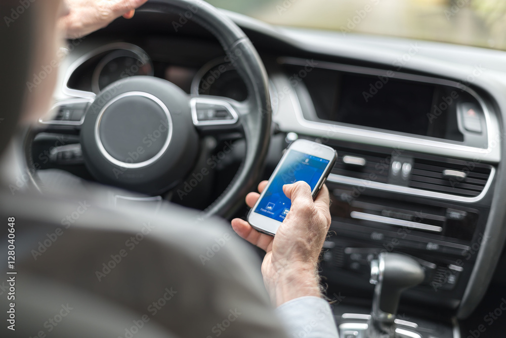 Man using a smartphone and driving