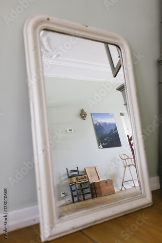 A antique mirror showing the view of a mint green interior. photo