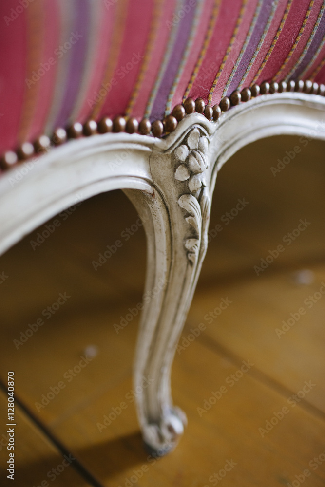 A white chair leg with carved ornaments. A white chair leg with carved ornaments.