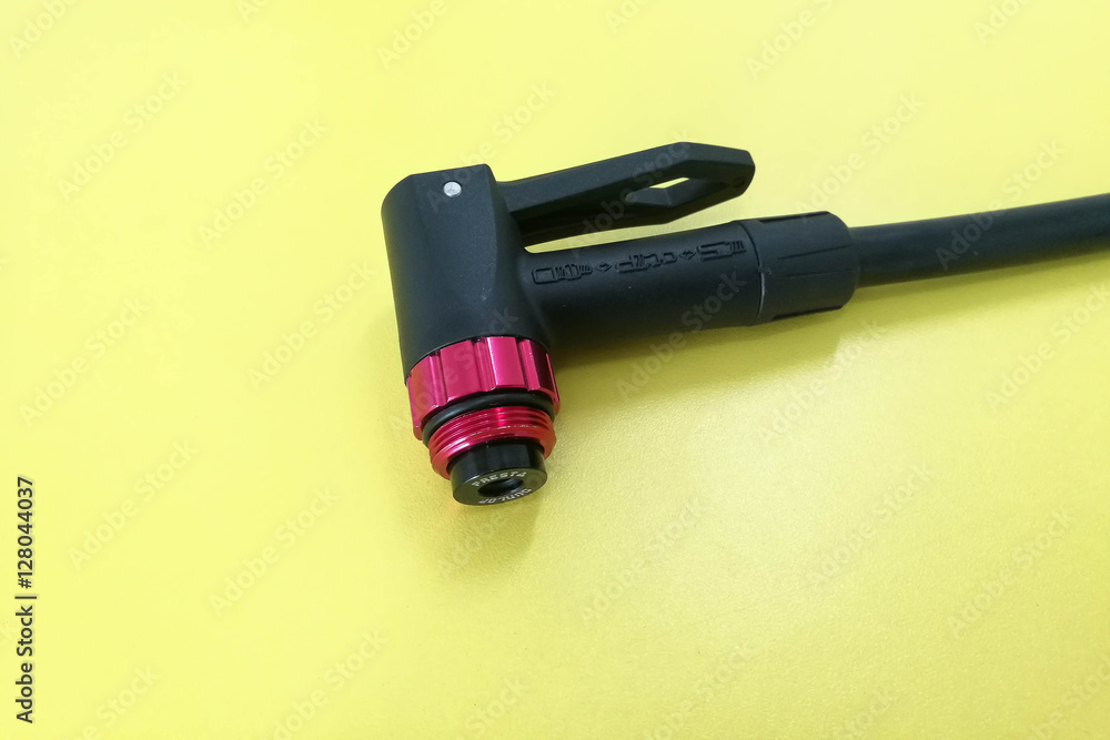 Closeup of a Air compressor bicycle pump mount isolated on yellow background, Closeup of a Air compressor bicycle pump mount isolated on yellow background,