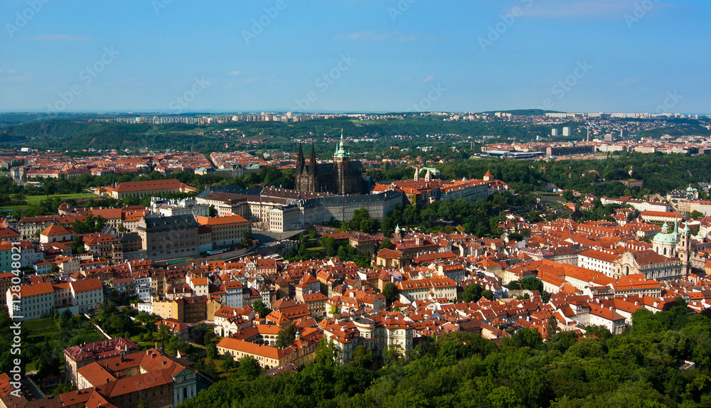 Panoramic view of the historical center of Prague, Czech Republic. St. Vitus cathedral, Prague Castle and typical Czech red roofed houses on a sunny day.
