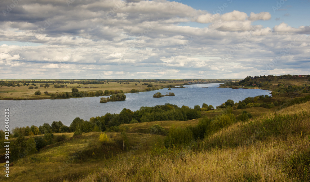 Typical russian landscape with river under cloudy sky