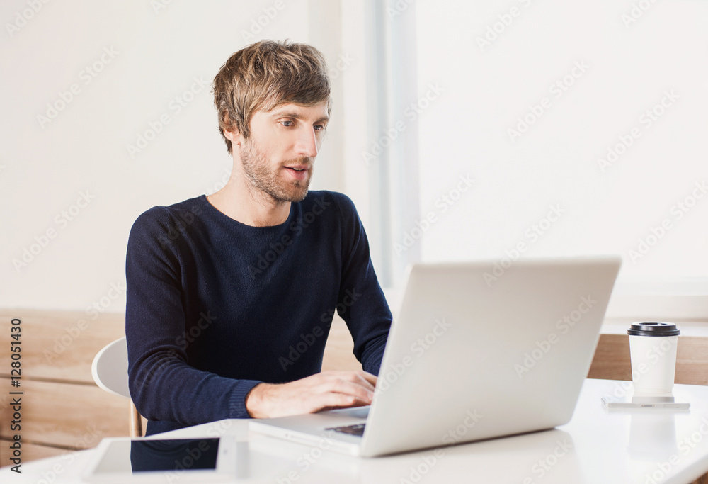 Portrait of a young business man working with laptop computer Portrait of a young business man working with laptop computer