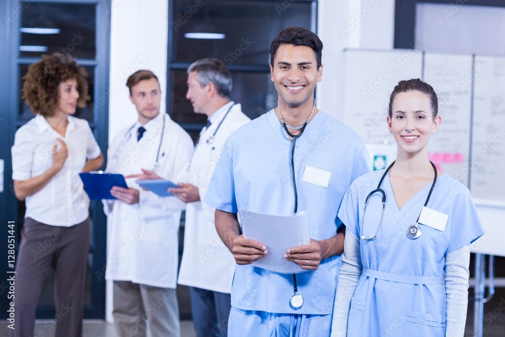 Doctor holding medical report and smiling at camera Doctor holding medical report and smiling at camera