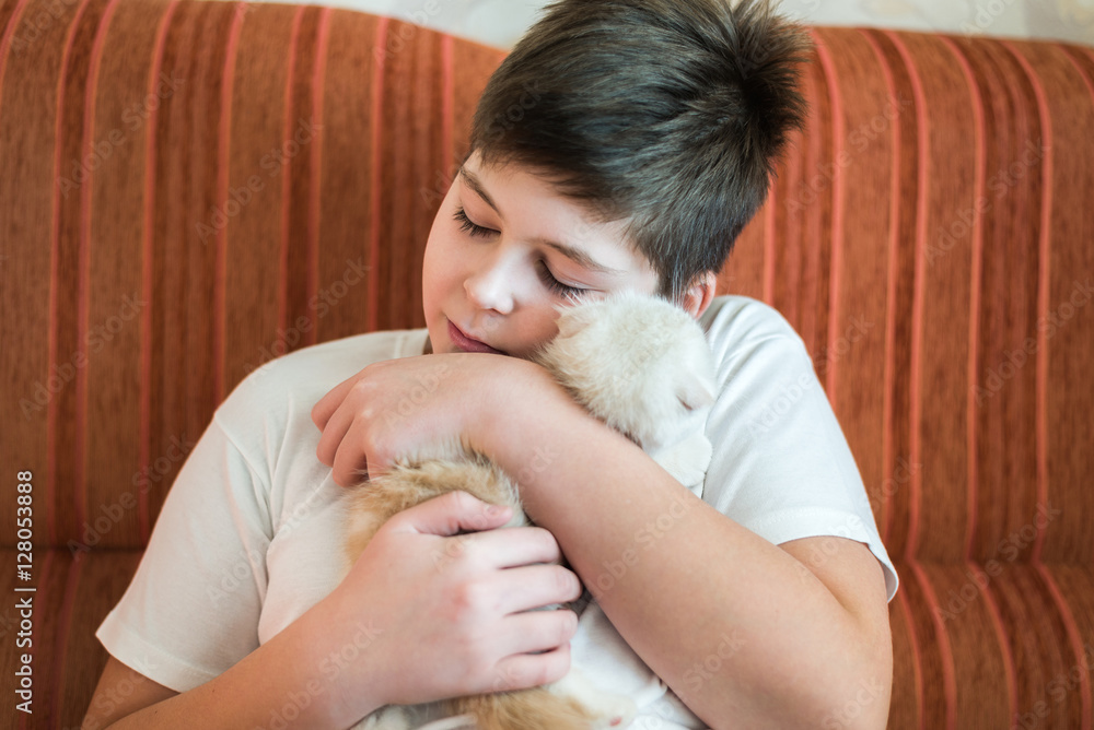 Boy teenager holding kitten in her arms Boy teenager holding kitten in her arms