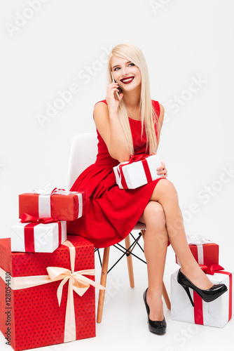 Woman in red dress with gifts talking on mobile phone