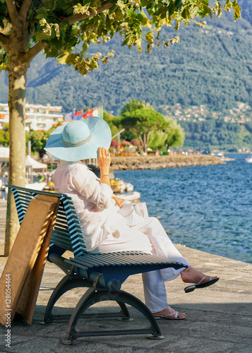 Senior lady sitting on bench of Ascona resort at Switzerland © Roman Babakin