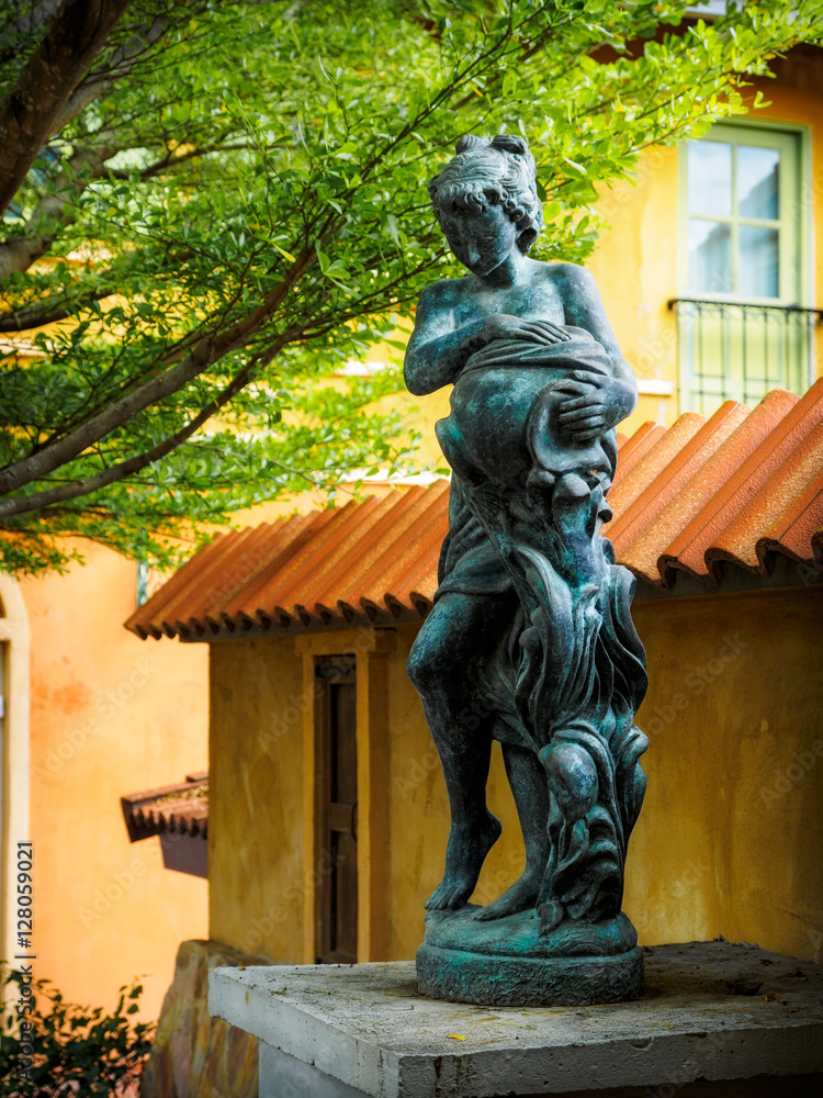 Obraz premium Statue of young girl with the jar in the summer garden