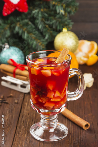 Mulled wine with citrus in glass on a dark wooden background