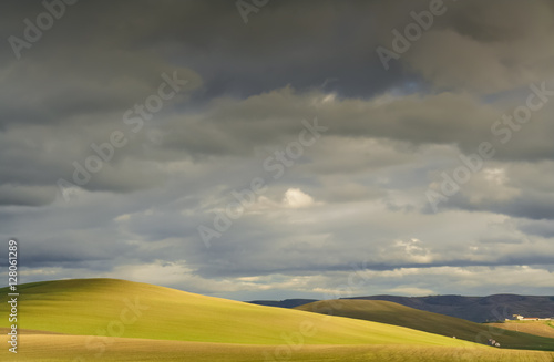 RURAL LANDSCAPE WINTER.Between Apulia and Basilicata. Hilly landscape with farmhouse dominated by thunderclouds. -ITALY- .Play of light on cultivated field dominated by thunderclouds.