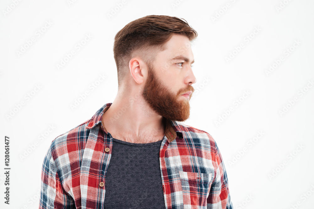 Serious bearded man in plaid shirt looking away Serious bearded man in plaid shirt looking away