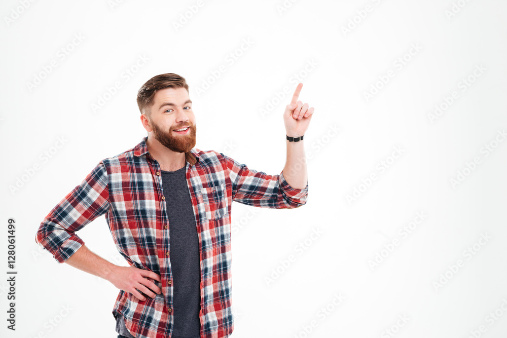 Smiling man in plaid shirt pointing finger up at copyspace Smiling man in plaid shirt pointing finger up at copyspace