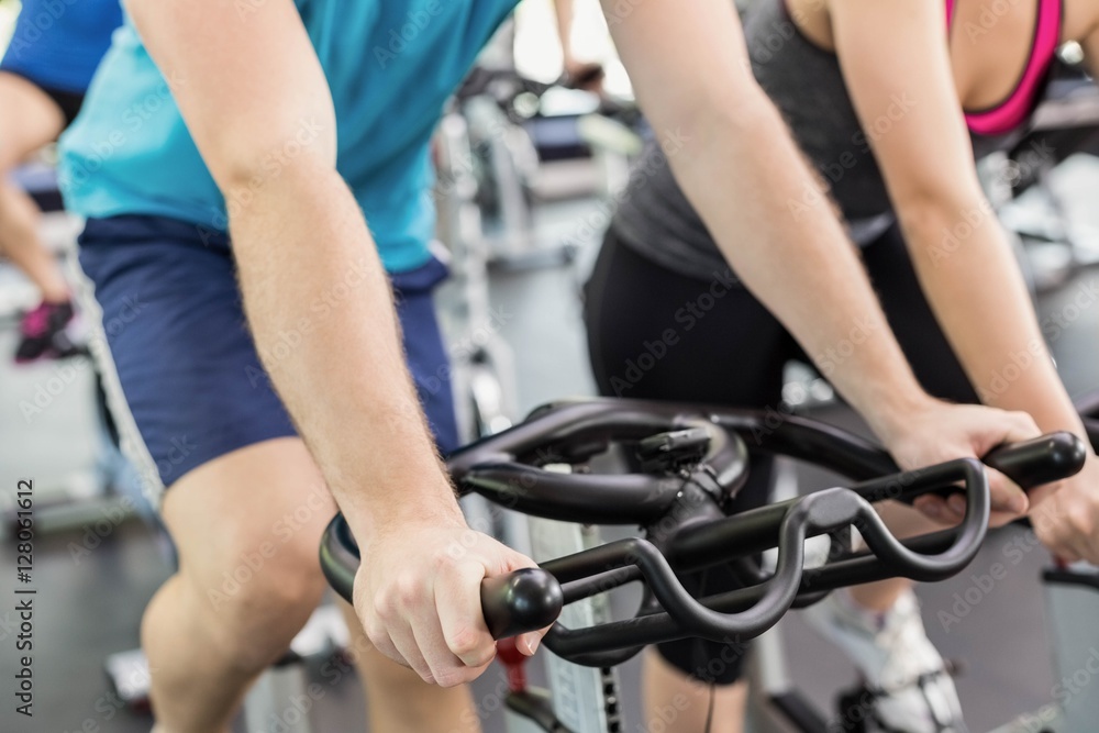 Fit group of people using exercise bike together Fit group of people using exercise bike together