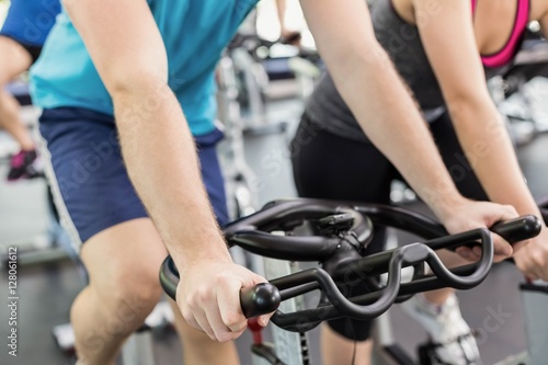 Fit group of people using exercise bike together © WavebreakMediaMicro