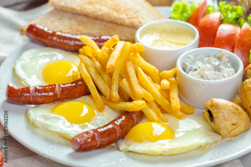 Fried eggs and fried sausage for breakfast