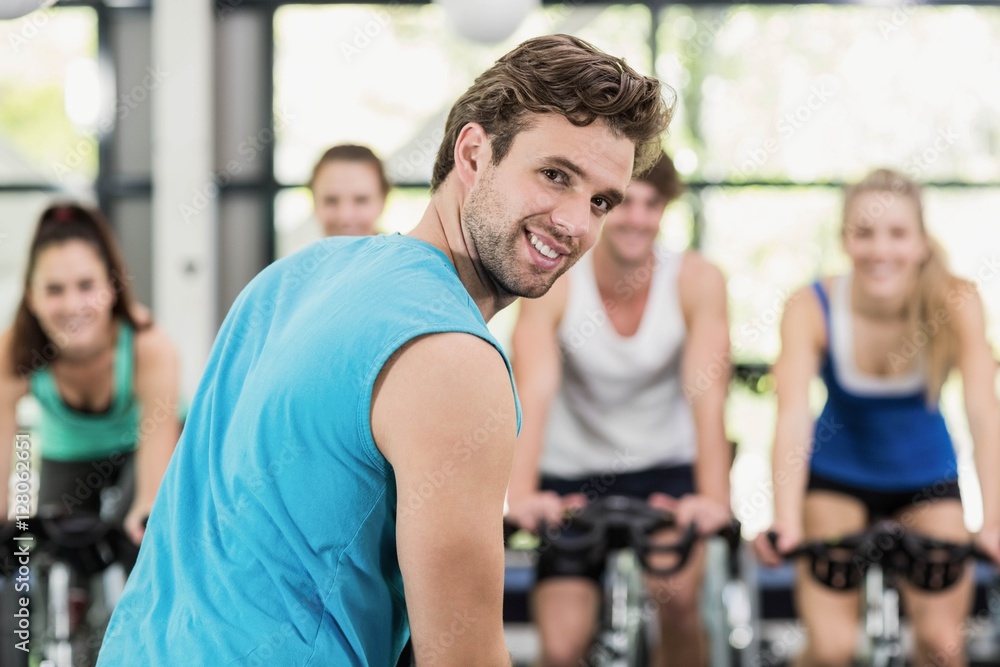 Fit group of people using exercise bike together