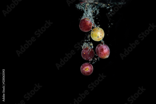 Fresh red grape in water with air bubbles water splash