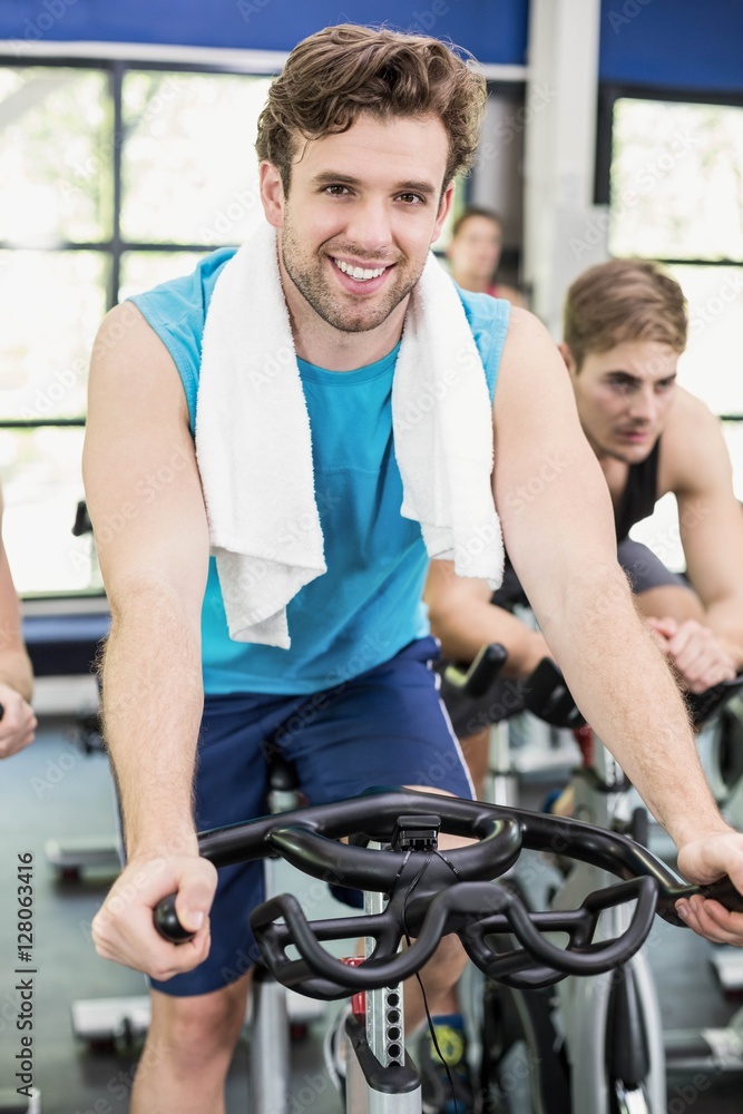 Obraz premium Fit group of people using exercise bike together