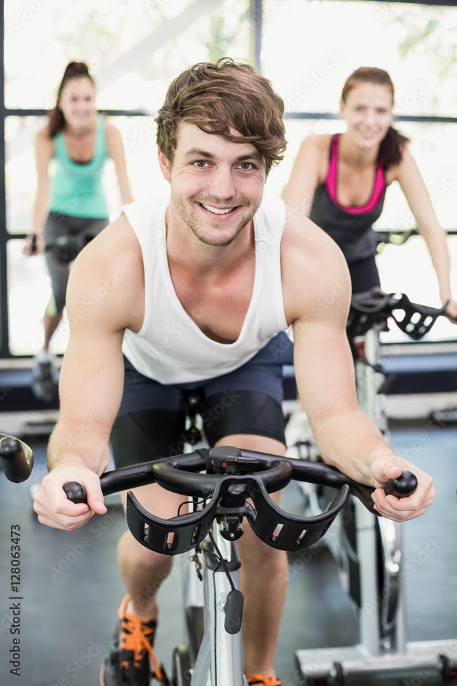 Fit group of people using exercise bike together Fit group of people using exercise bike together