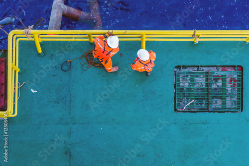 Offshore workers having a discussion prior to anchor handling activity at a bow of a construction barge at oilfield Terengganu, Malaysia