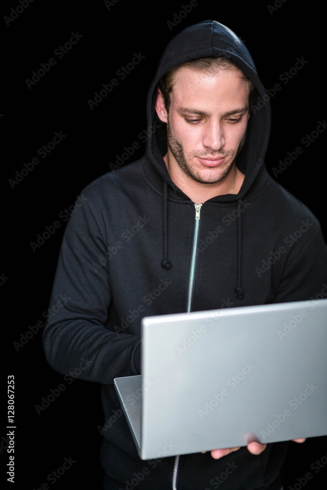 Handsome man in black hoodie using laptop Handsome man in black hoodie using laptop