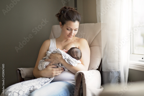 Mother breastfeeding her little baby boy in  arms. photo