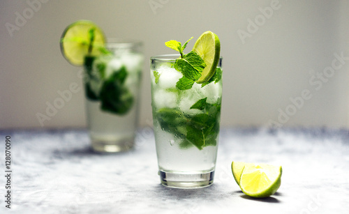 Mojito cocktail with lime and mint in glass on a white background