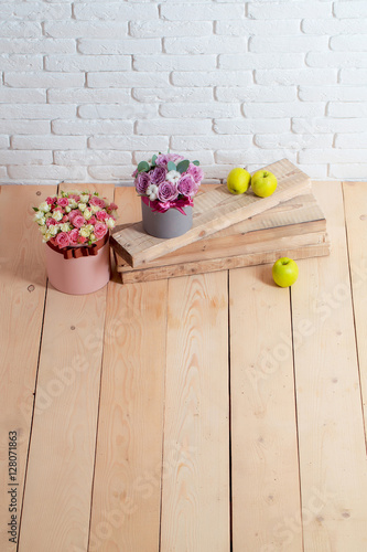 flowers and apple on wooden planks