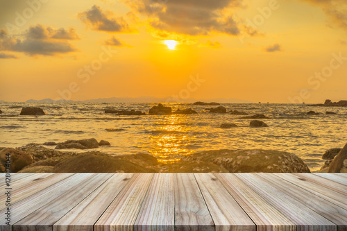 Empty wooden table or shelf wall with sunset or sunrise on sand