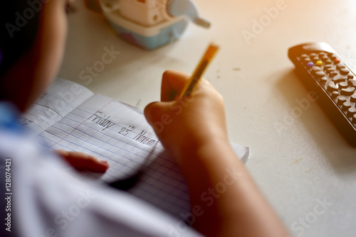 A teen school girl studies hard over his book at home