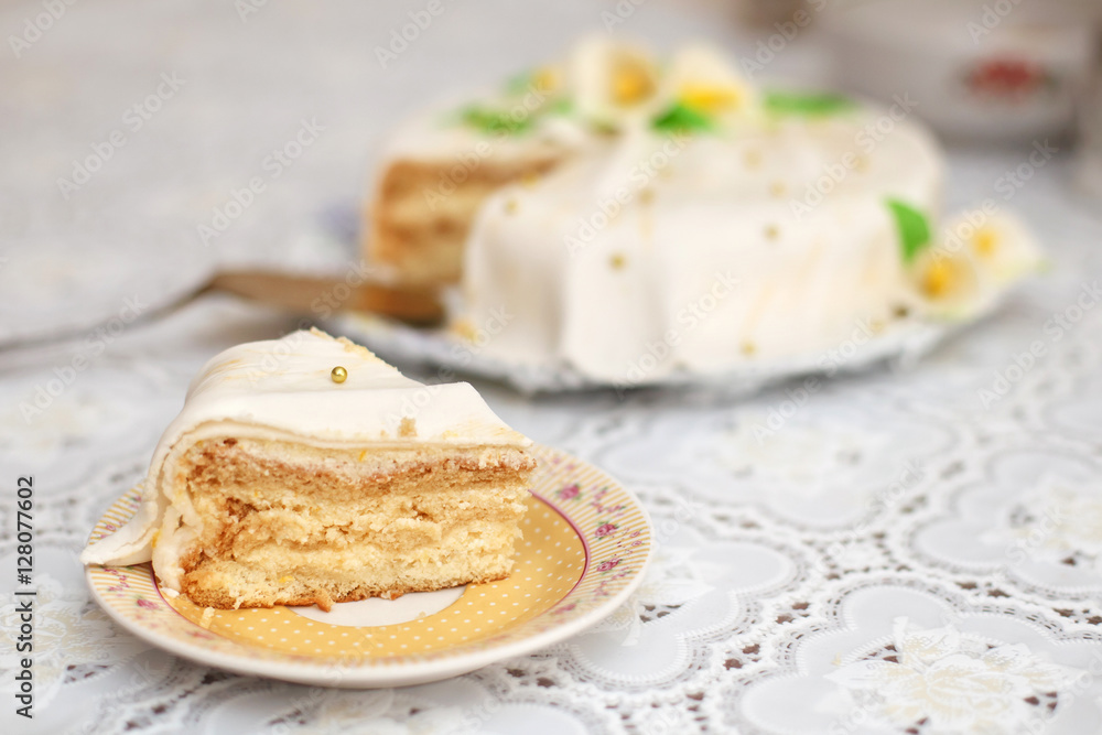 Piece of white mastic cake decorated with flowers, closeup Piece of white mastic cake decorated with flowers, closeup