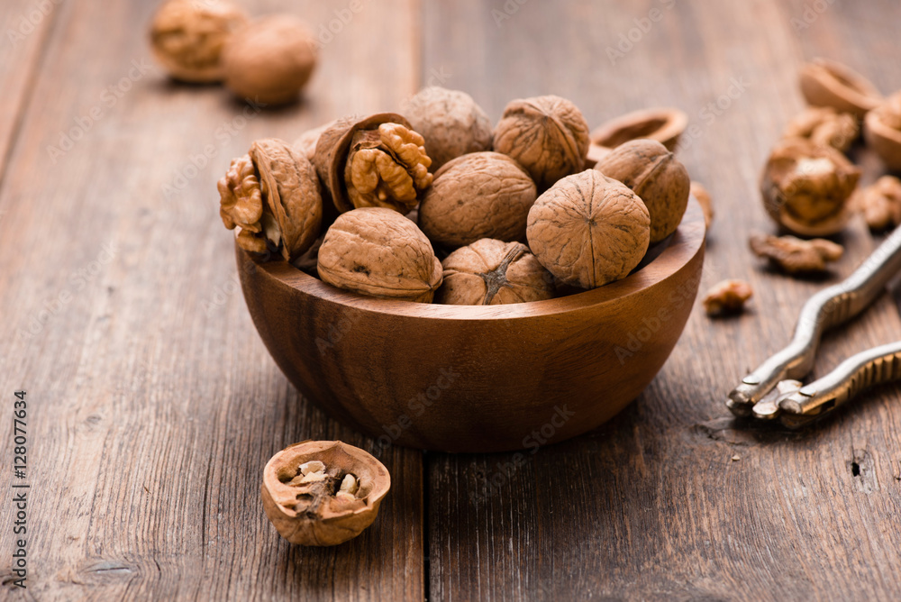 Walnuts in wooden bowl on table with Nutcracker. Walnuts in wooden bowl on table with Nutcracker.