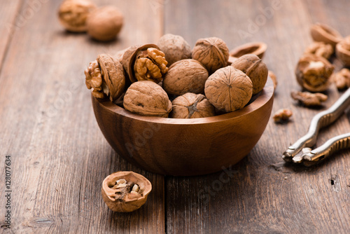 Walnuts in wooden bowl on table with Nutcracker.