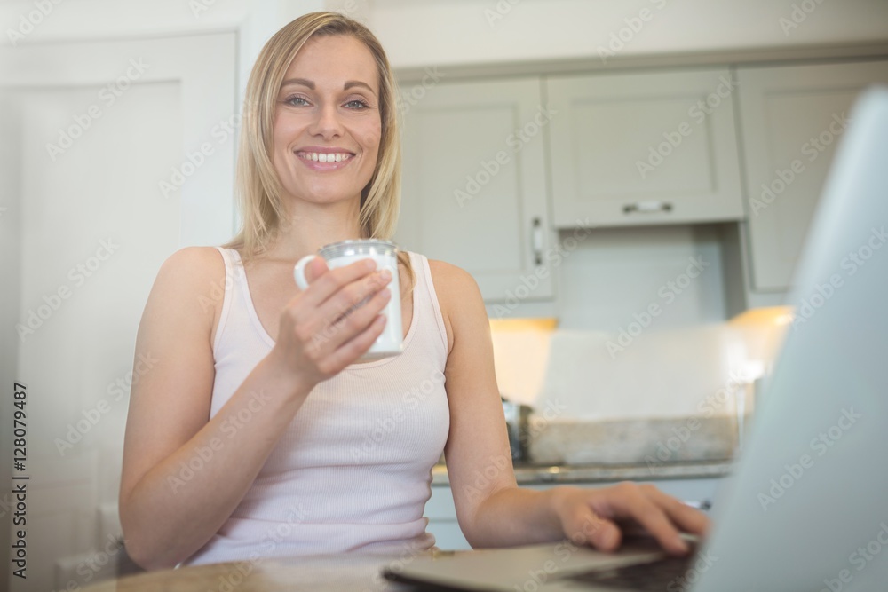 Pretty blonde woman having coffee and using laptop Pretty blonde woman having coffee and using laptop