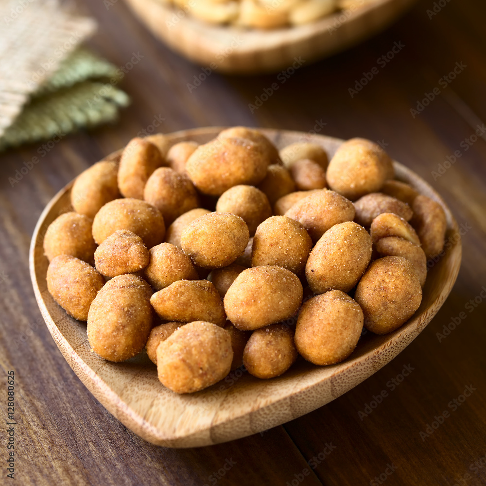 Roasted peanuts in spicy coat, photographed on dark wood with natural light (Selective Focus, Focus one third into the peanuts) Roasted peanuts in spicy coat, photographed on dark wood with natural light (Selective Focus, Focus one third into the peanuts)