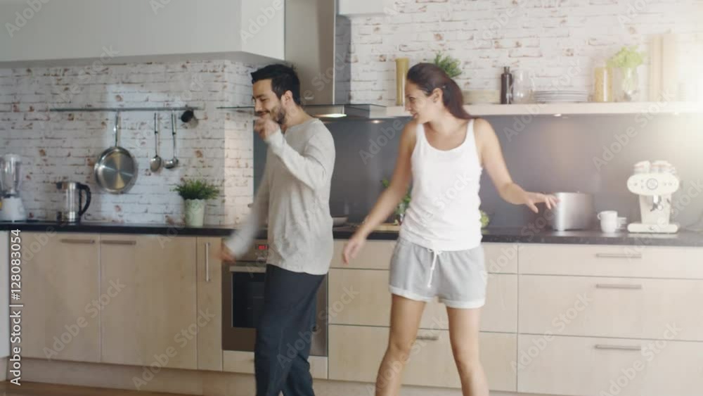 Happy Couple Creatively Dances in the Kitchen. Both are Adorable and Smiling. Shot on RED Cinema Camera in 4K (UHD). Happy Couple Creatively Dances in the Kitchen. Both are Adorable and Smiling. Shot on RED Cinema Camera in 4K (UHD).