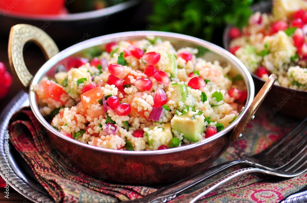 Healthy salad with couscous, tomato, avocado, red onion, pomegranate and olive oil. Eastern cuisine. Healthy salad with couscous, tomato, avocado, red onion, pomegranate and olive oil. Eastern cuisine.