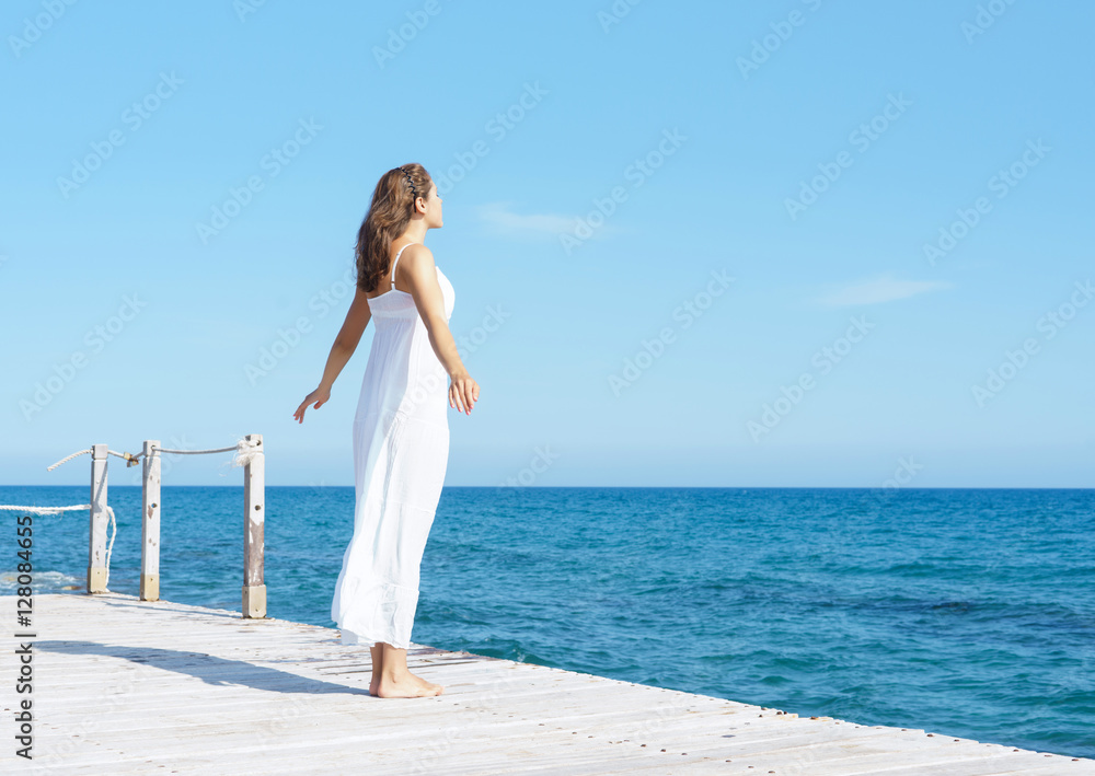 Woman in a white dress on a wooden pier Woman in a white dress on a wooden pier