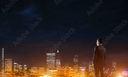 Businessman viewing night glowing city