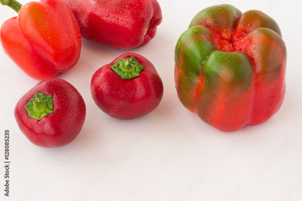 Red peppers with water droplets on a white background. Red peppers with water droplets on a white background.